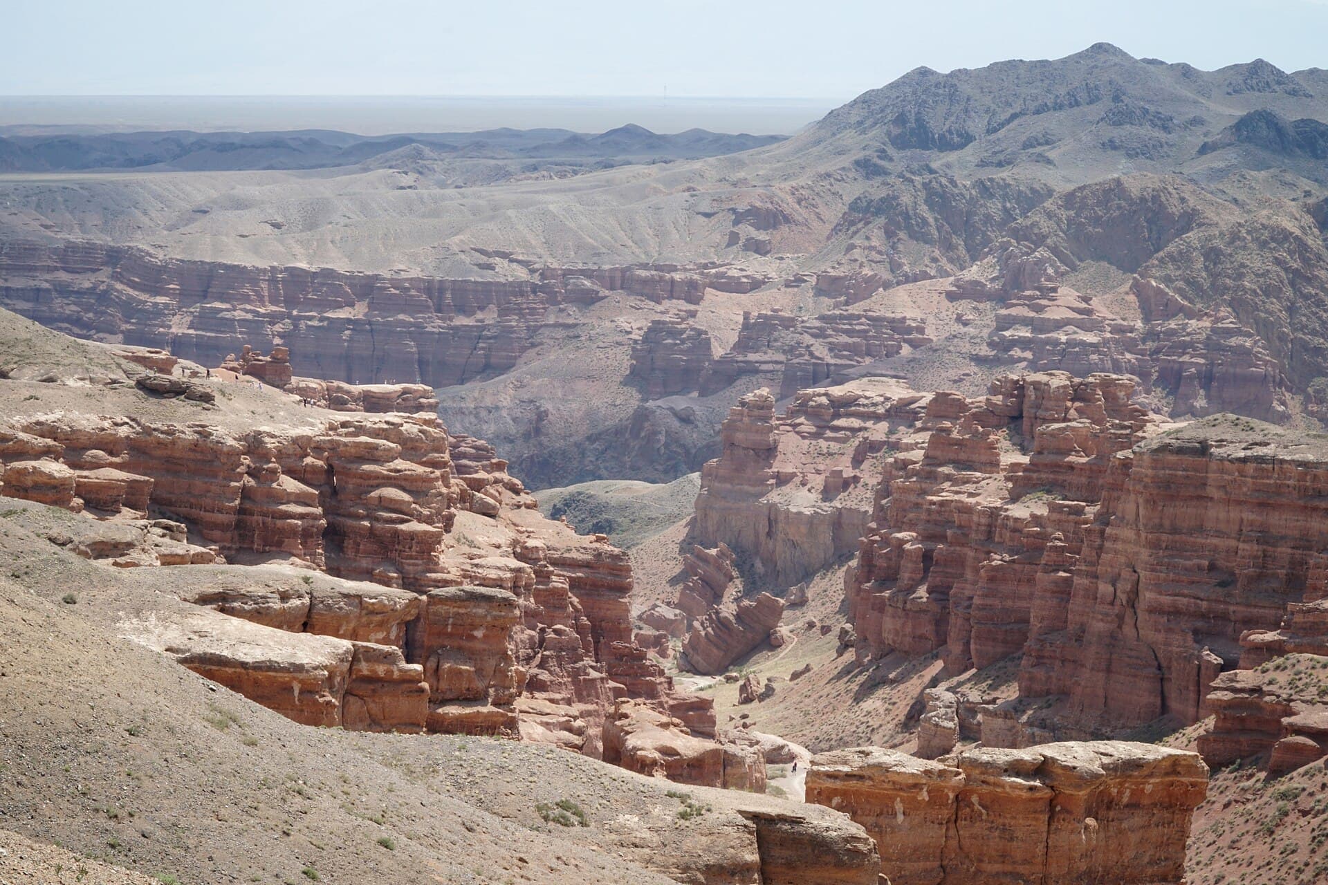 Red sandstone formations and a winding dry riverbed in Charyn Canyon, Kazakhstan